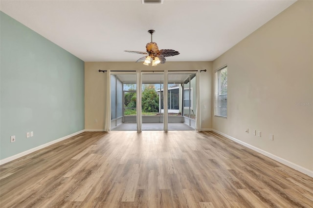 unfurnished room with a healthy amount of sunlight, light hardwood / wood-style flooring, and ceiling fan