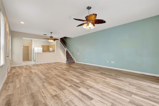 unfurnished living room featuring ceiling fan and light hardwood / wood-style flooring