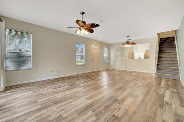 unfurnished living room with ceiling fan, a healthy amount of sunlight, and light hardwood / wood-style floors