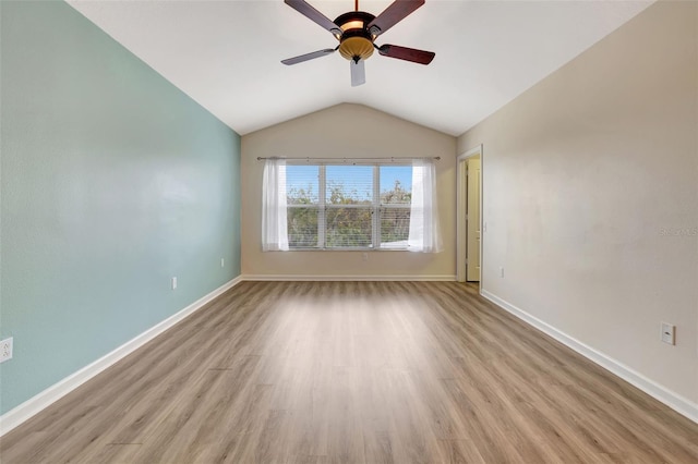 empty room featuring light hardwood / wood-style floors, vaulted ceiling, and ceiling fan