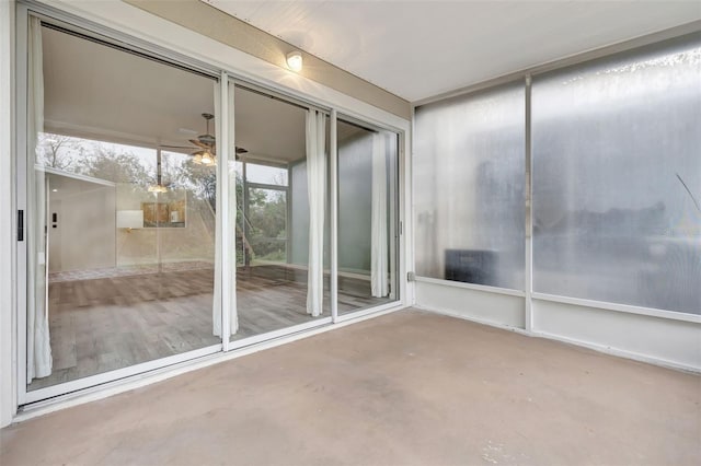 unfurnished sunroom with ceiling fan