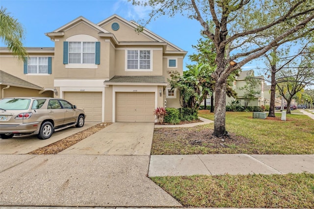 townhome / multi-family property with a garage and a front lawn