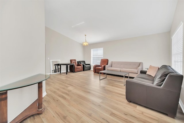 living room featuring lofted ceiling and light hardwood / wood-style flooring