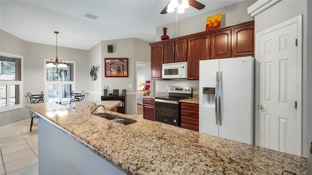 kitchen featuring light tile patterned flooring, sink, pendant lighting, white appliances, and light stone countertops