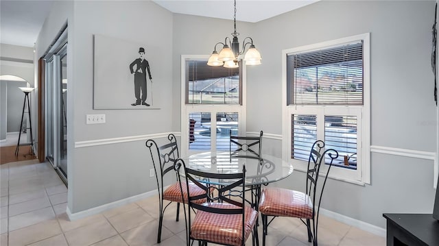 tiled dining room with an inviting chandelier