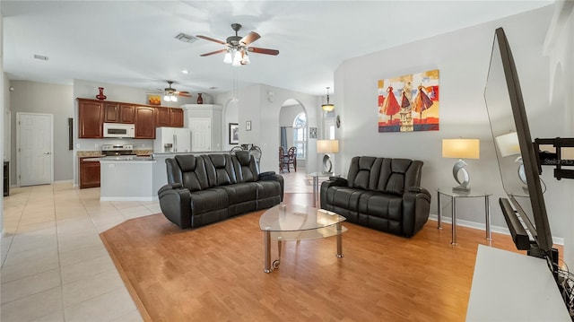 tiled living room featuring vaulted ceiling and ceiling fan