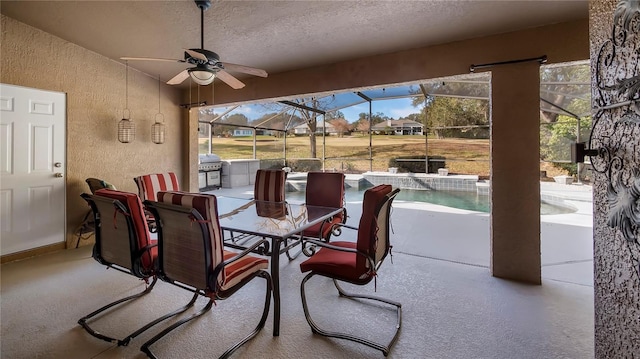 view of patio with an outdoor kitchen, ceiling fan, and glass enclosure