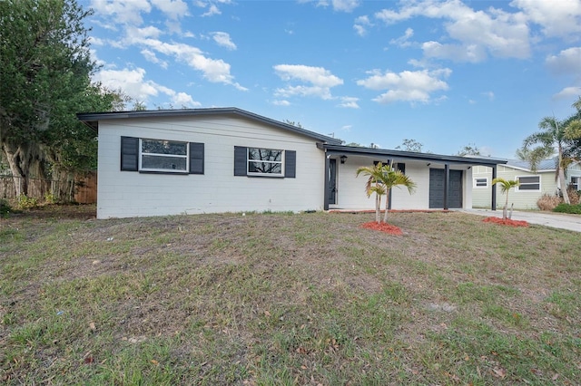 ranch-style home featuring a front lawn and a carport