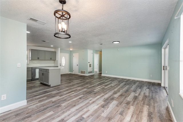 kitchen with hardwood / wood-style floors, decorative light fixtures, dishwasher, gray cabinetry, and a center island