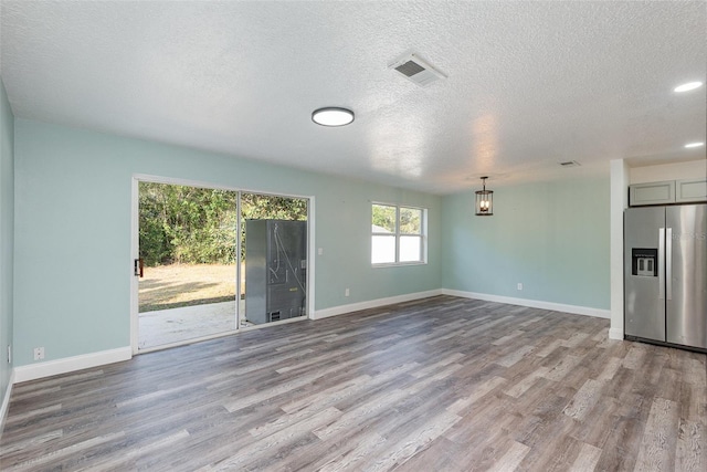 unfurnished living room featuring a textured ceiling and light wood-type flooring