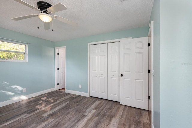 unfurnished bedroom featuring ceiling fan, dark wood-type flooring, a closet, and a textured ceiling