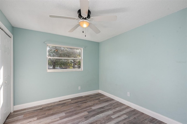 spare room featuring wood-type flooring, ceiling fan, and a textured ceiling