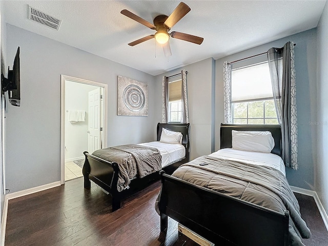 bedroom with ensuite bath, dark hardwood / wood-style floors, and ceiling fan