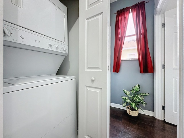 laundry area with dark wood-type flooring and stacked washer and clothes dryer