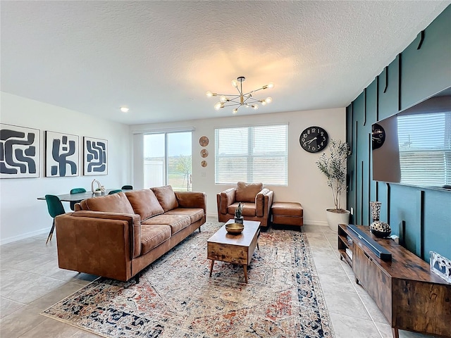 living room with light tile patterned flooring, an inviting chandelier, and a textured ceiling