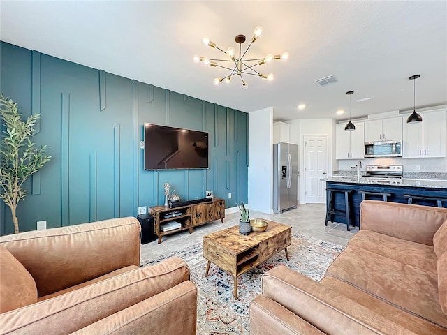 living room featuring sink, an inviting chandelier, and light tile patterned flooring