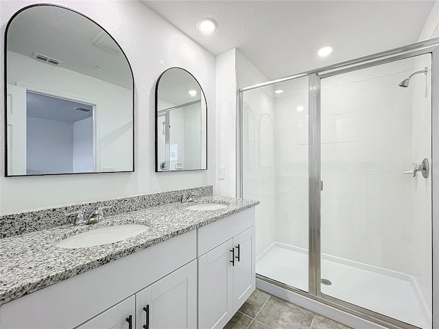 bathroom featuring vanity, tile patterned floors, and a shower with door