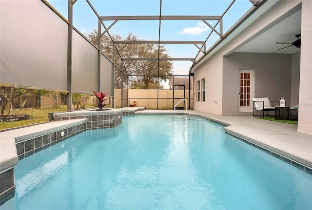 view of swimming pool with glass enclosure, a patio area, and ceiling fan