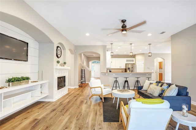 living room with ceiling fan and light hardwood / wood-style floors