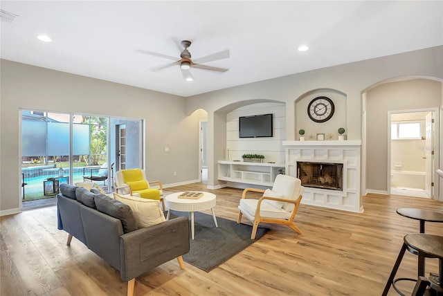 living room featuring ceiling fan and light hardwood / wood-style floors