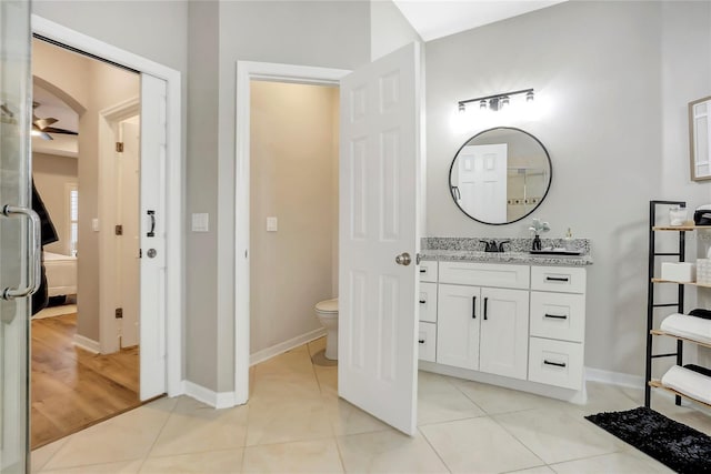 bathroom with toilet, vanity, and tile patterned flooring