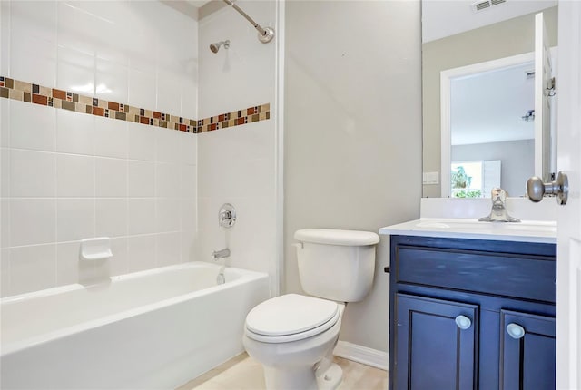 full bathroom featuring tiled shower / bath combo, toilet, and vanity