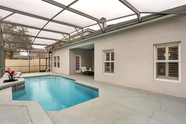 view of swimming pool featuring a patio area, a lanai, and ceiling fan