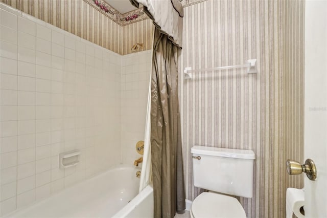 bathroom featuring shower / bath combo with shower curtain, toilet, and wallpapered walls