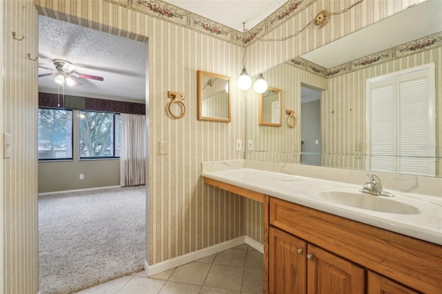 bathroom featuring wallpapered walls, baseboards, and a textured ceiling