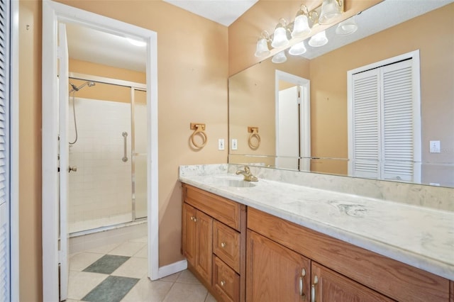 bathroom featuring baseboards, a shower stall, vanity, and tile patterned floors