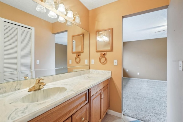 bathroom with tile patterned flooring, baseboards, and vanity