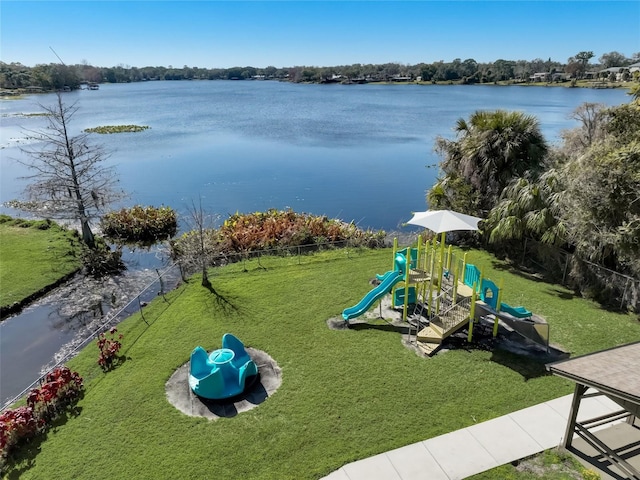 communal playground featuring a yard, a water view, and fence