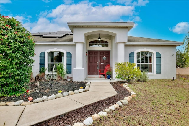 property entrance with a yard and solar panels