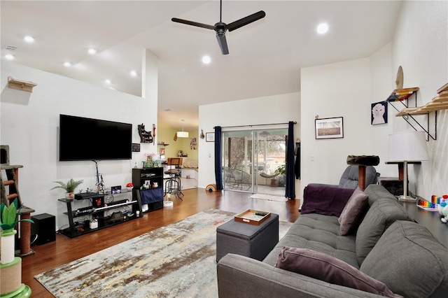 living room featuring hardwood / wood-style flooring, ceiling fan, and high vaulted ceiling