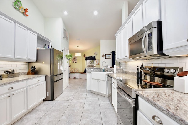 kitchen featuring sink, white cabinets, decorative backsplash, light tile patterned floors, and stainless steel appliances