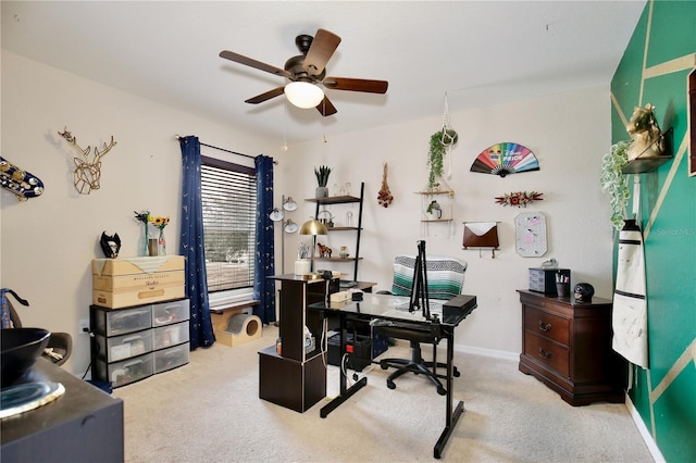 carpeted home office featuring ceiling fan