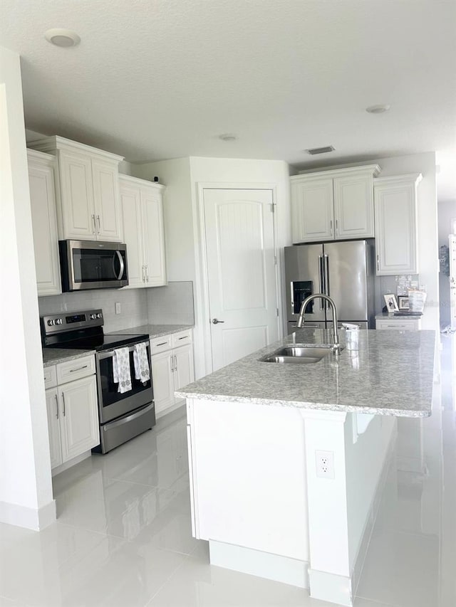 kitchen featuring sink, white cabinetry, a kitchen island with sink, and appliances with stainless steel finishes