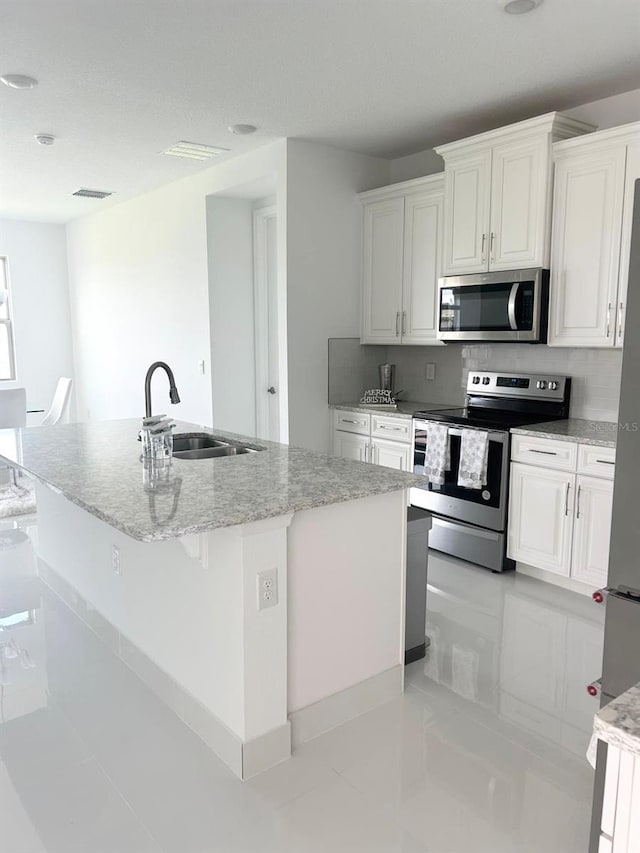 kitchen featuring sink, an island with sink, white cabinetry, and stainless steel appliances