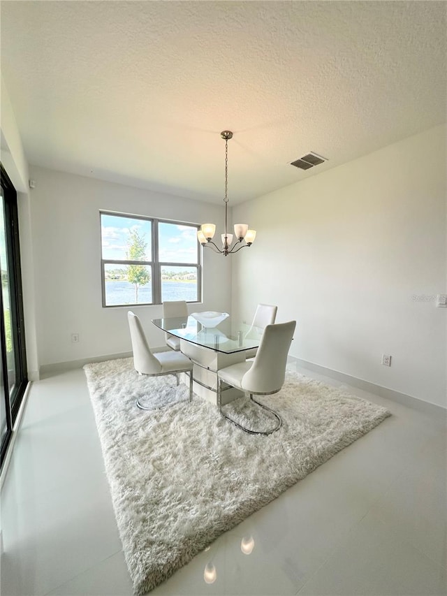 dining space with a chandelier and a textured ceiling