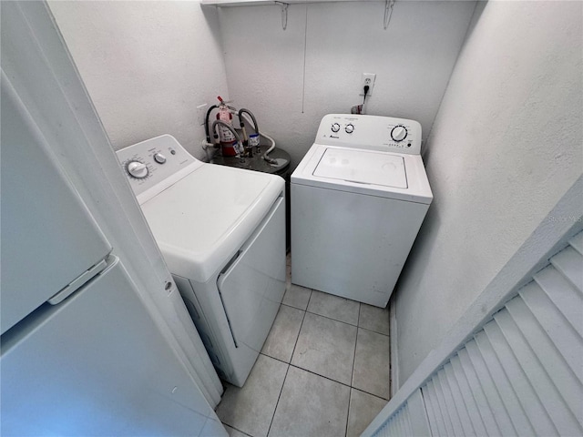 laundry room with washer and dryer and light tile patterned floors