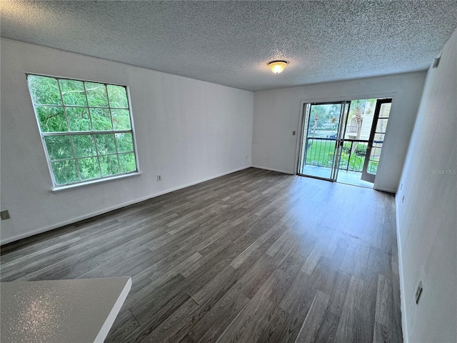 empty room featuring dark wood-type flooring and a textured ceiling