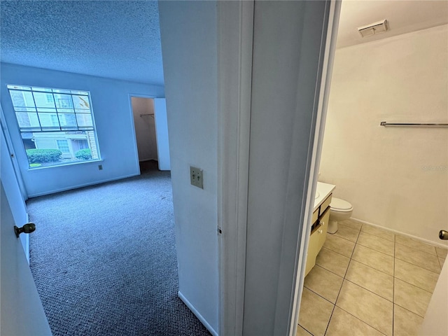 bathroom with toilet, a textured ceiling, tile patterned floors, and vanity