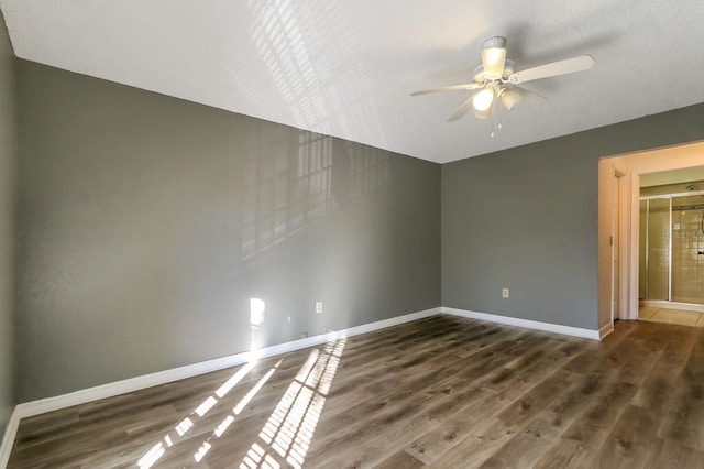 empty room featuring ceiling fan and dark hardwood / wood-style flooring