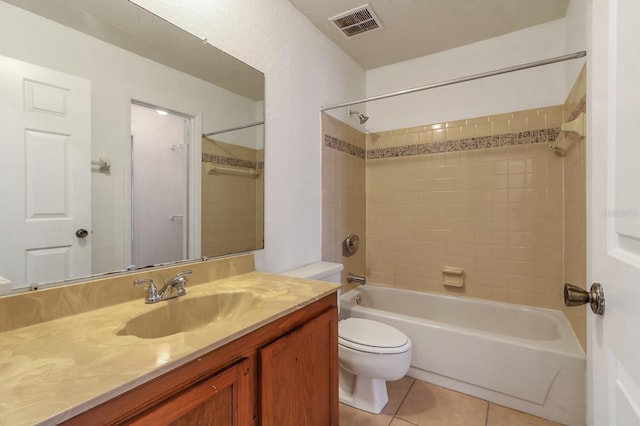 full bathroom featuring vanity, toilet, tile patterned floors, and tiled shower / bath