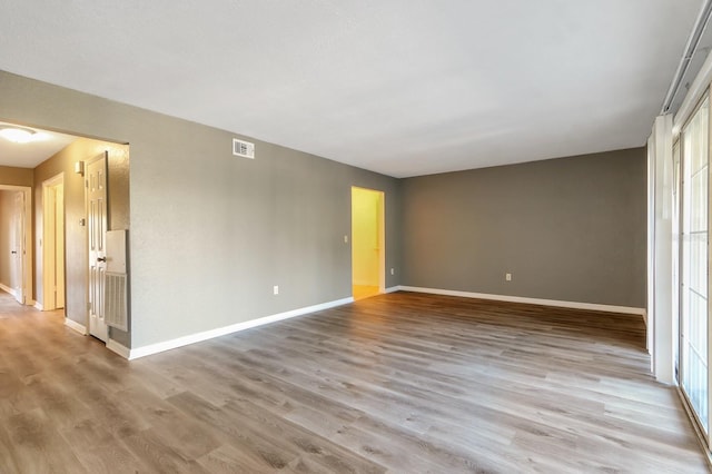 empty room featuring a wealth of natural light and light hardwood / wood-style flooring