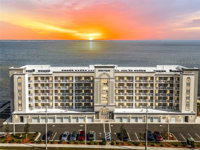 aerial view at dusk featuring a water view