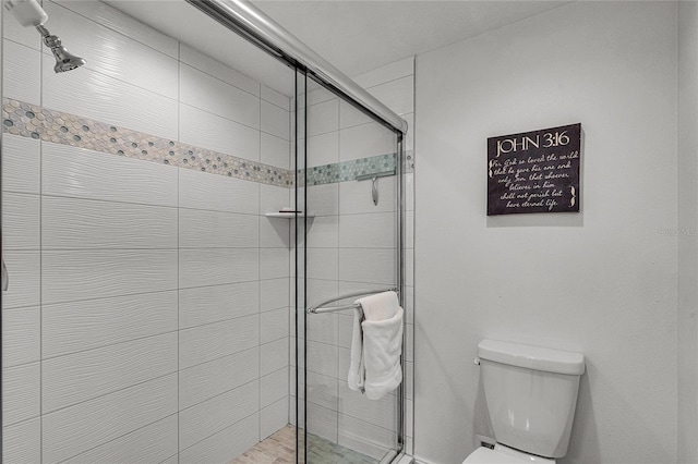 bathroom with a shower stall and toilet