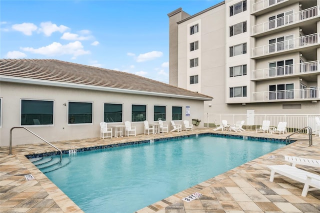 community pool featuring a patio and fence