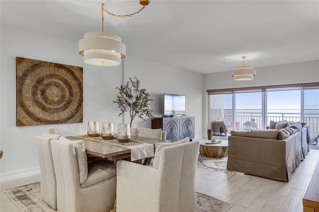 dining space featuring baseboards and light wood finished floors