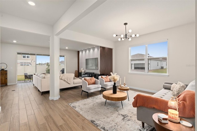 living room with beam ceiling, a chandelier, and light wood-type flooring